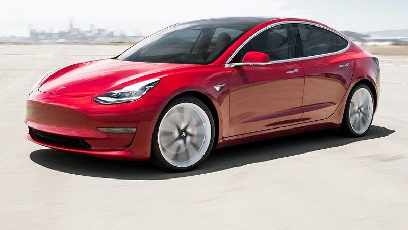 2020 Tesla Model 3 in red driving on a track