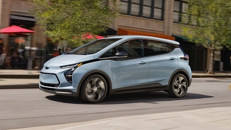 2023 Chevrolet Bolt EV side profile while driving on an urban city street