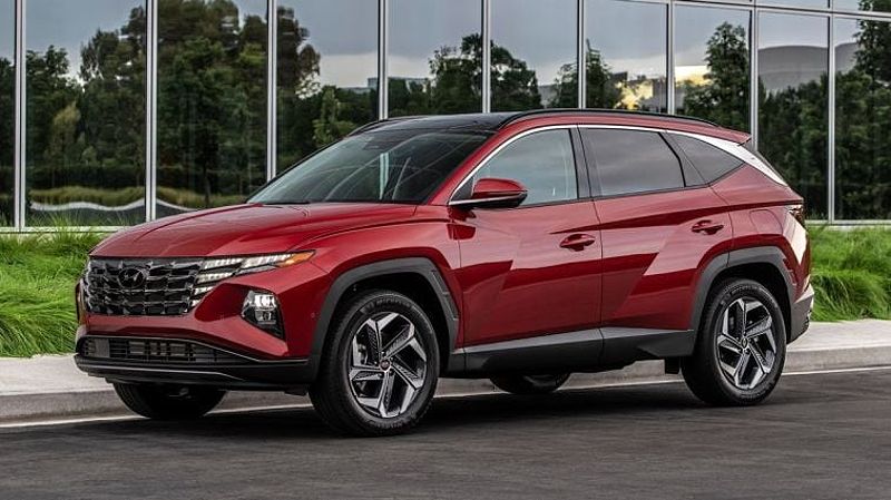 2024 Hyundai Tucson in red parked in front of a glass building