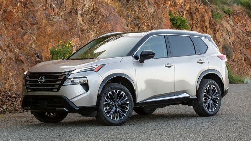 2024 Nissan Rogue Platinum with a rock wall in the background