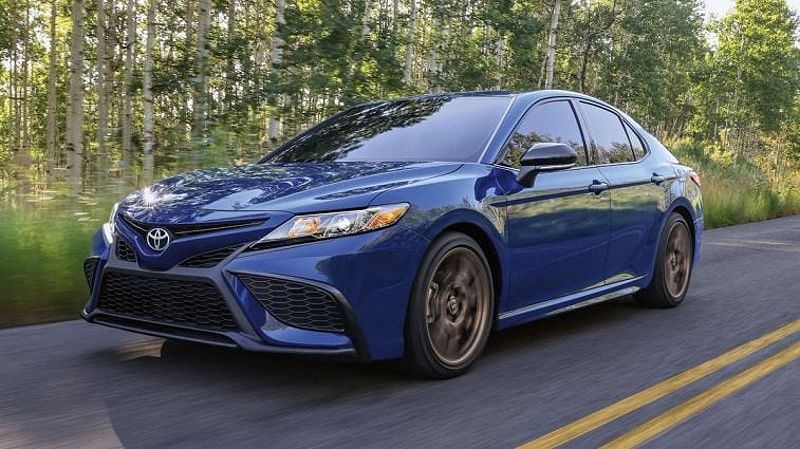 2024 Toyota Camry SE Nightshade in blue driving by trees